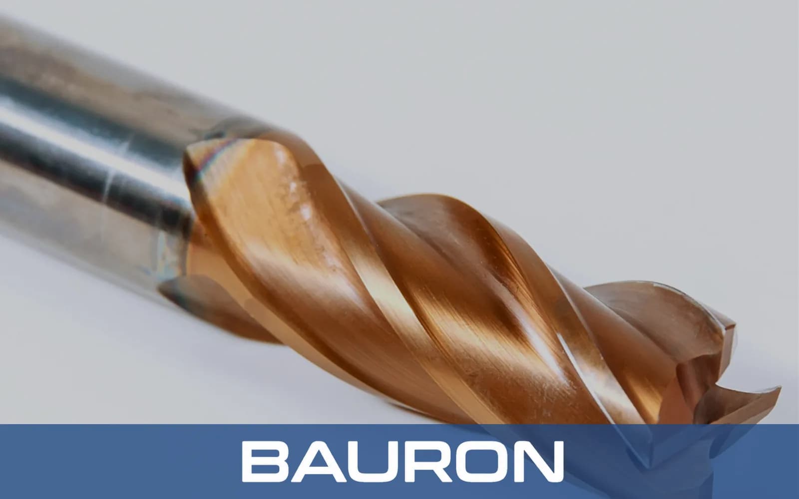 Close-up van een bronsgecoate hardmetalen frees met vier groeven